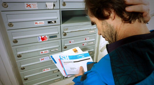 Mann hält einen Brief mit dem Titel Inkassobüro in der Hand | FSW